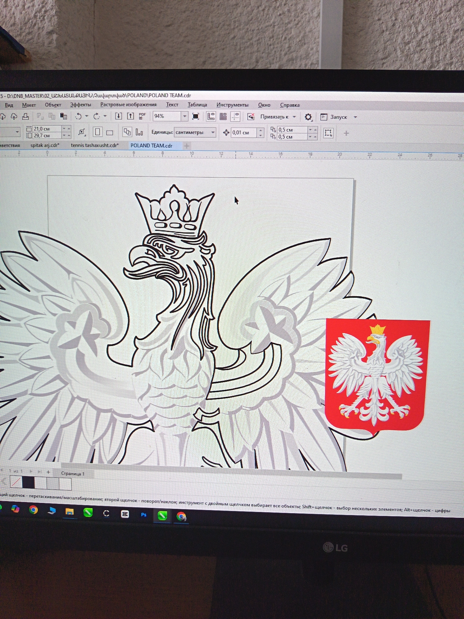 The image shows a computer screen displaying graphic design software, likely CorelDRAW given the filename "POLAND TEAM.cdr" and the interface elements. The software is open to a design featuring the Polish coat of arms, a white eagle with a crown, wings spread, against a gray background with a smaller, colored version of the coat of arms on a red shield to the right. The Polish flag colors, red and white, are visible in the smaller shield. The computer screen is positioned on a desk, and the environment appears to be indoors, with a textured wall visible in the background. The image does not contain any identifiable landmarks or clues that would allow for determining a specific location within Yerevan, Armenia, or any other city.