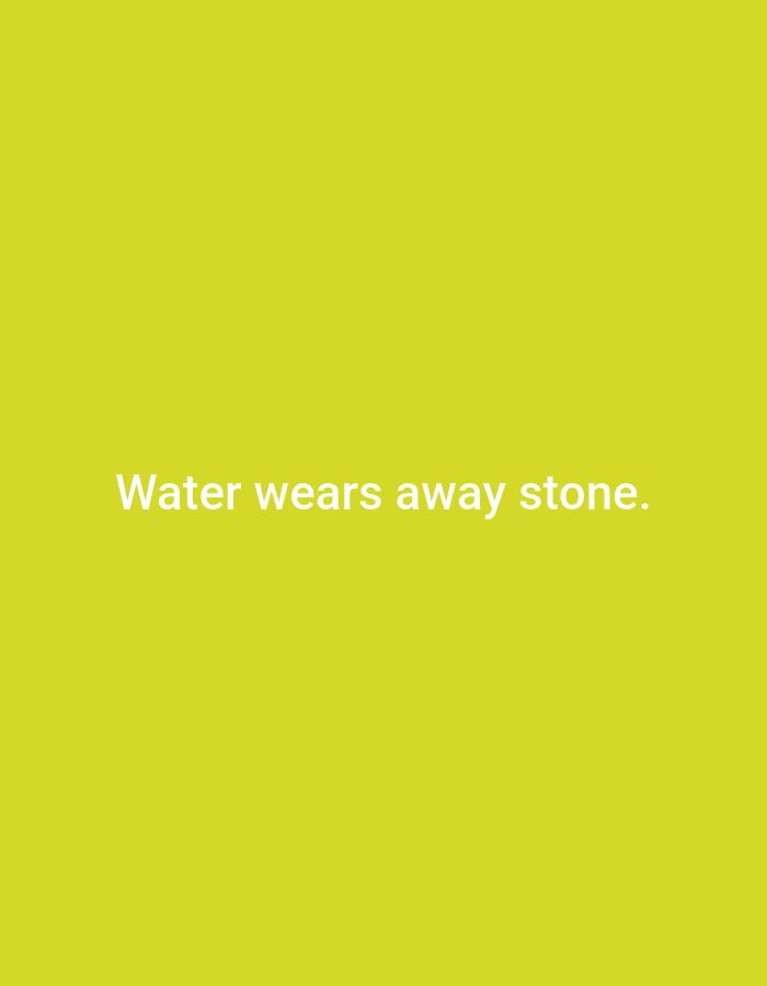 The image is a plain, solid bright yellow background with white text centered on it. The text reads "Water wears away stone." There are no people, objects, or environmental details visible in the image. It is impossible to determine the location in Kaliningrad, Russia, from this image.