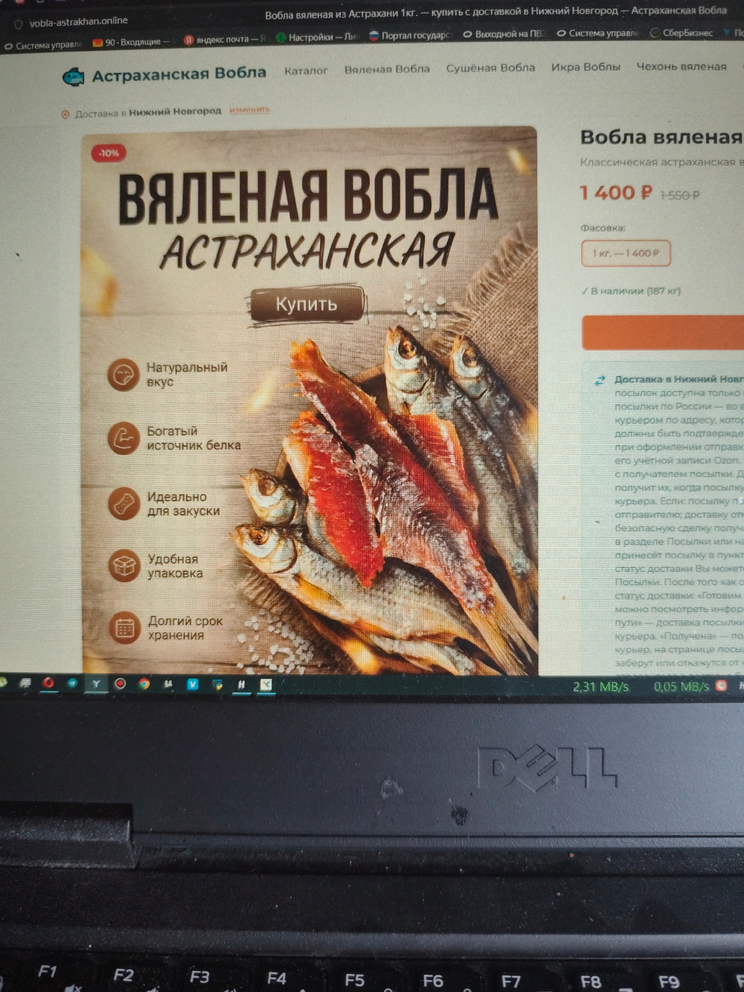 The image displays a screenshot of a website on a laptop. The website appears to be an online store selling "Astrakhan dried fish" (Вобла астраханская). The main product featured is "Dried Astrakhan Vobla" with a price of 1400 rubles per kilogram. Several benefits of the product are listed, such as "Natural taste," "Rich source of protein," "Ideal for snacks," "Convenient packaging," and "Long shelf life." There's also information about delivery to Nizhny Novgorod, with details about the shipping process. The bottom of the image shows a portion of a black Dell laptop keyboard. The image does not provide any information about the city of Bor, Russia.