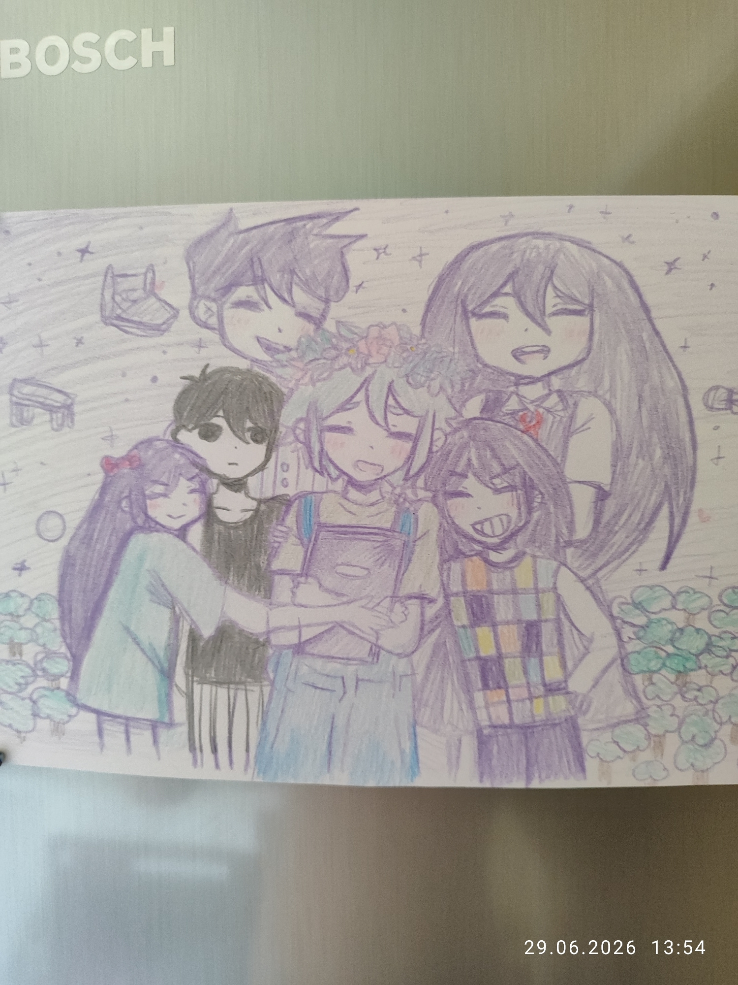 A drawing on a light green surface, possibly a refrigerator, depicts a group of six characters with large heads and simple features. They are all colored with light shades of purple, blue, and gray. Some characters are wearing simple clothing, such as a light blue t-shirt, a dark t-shirt, and a checkered vest. One character has a flower crown. The background is lightly sketched with small crosses and circles, suggesting a starry or whimsical setting. There are also faint sketches of furniture, resembling a chair and a bed. The overall style is reminiscent of anime or manga artwork. The timestamp "29.06.2026 13:54" is visible at the bottom right of the image. The "BOSCH" logo is visible at the top left of the surface. This image has no discernible connection to the city of Northampton, United Kingdom.