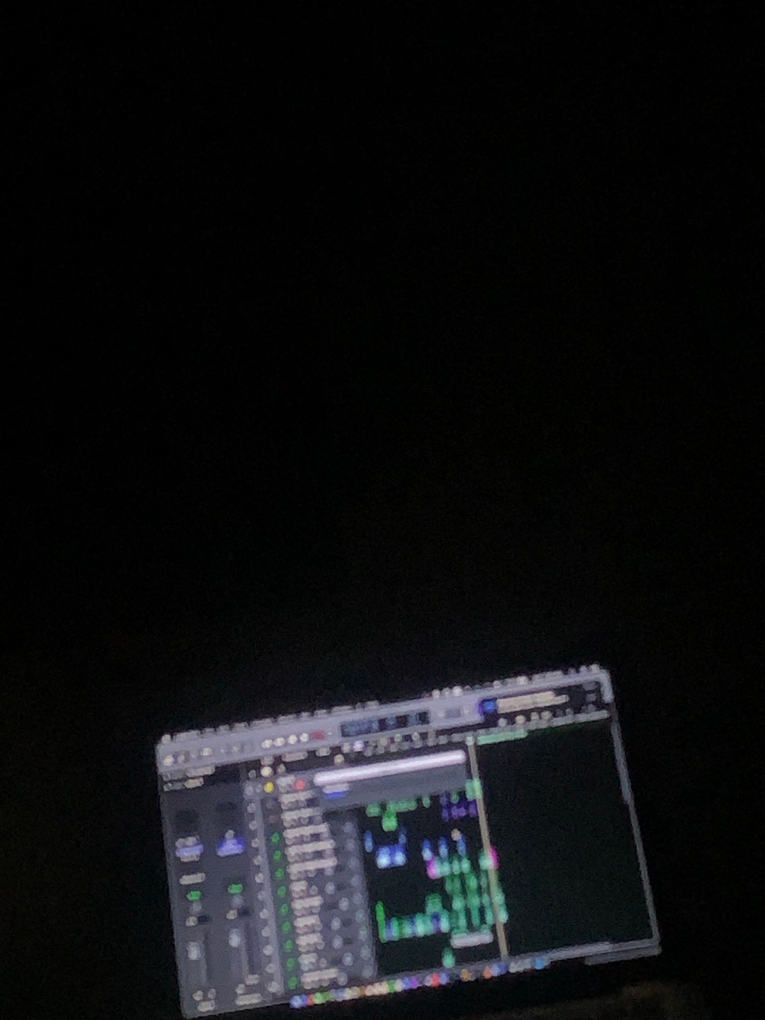 The image shows a computer screen displaying a digital audio workstation (DAW) software. The screen is in focus, while the surrounding environment is dark, suggesting the photo was taken in low light conditions. The DAW interface features multiple tracks with faders, meters, and waveform displays, indicating that audio editing or production is in progress. The specific location in Jalingo, Nigeria, is not discernible from the image.