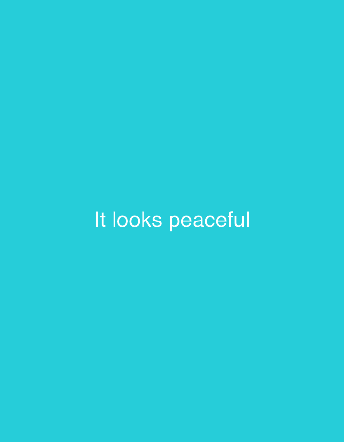 The image displays a solid turquoise background with the white text "It looks peaceful" centered horizontally and vertically. There is no discernible location in Jalingo, Nigeria, or any people, subjects, objects, actions, or interactions visible. The scene is entirely abstract and devoid of any environmental context.