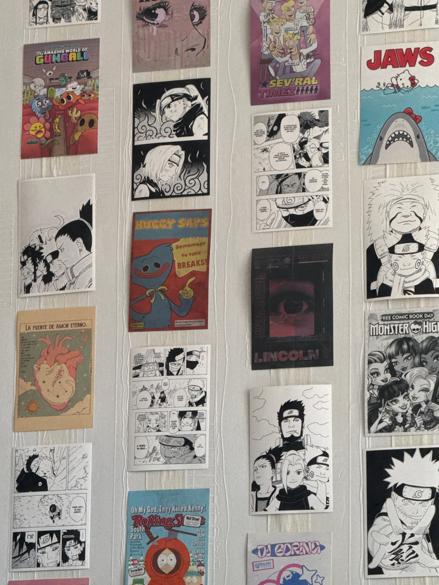 The image displays a collection of roughly square and rectangular postcards or stickers arranged on a white, textured surface. The items are a mix of anime-style drawings, cartoon characters, and graphic designs.
In the top row, from left to right, are fragments of manga panels featuring a character's face, a postcard with "JAWS" in large red letters and a cartoon shark, another postcard with a smiling shark, a "FREE COMIC BOOK DAY MONSTER HIGH" sticker featuring multiple anime-style female faces, and a drawing of a character resembling Naruto.
The second row starts with a postcard featuring characters from "The Amazing World of Gumball," followed by manga panels and a black rectangle with an eye image and text that includes "LINCOLN" and "INEVER PROMISED YOU A ROSE GARDEN."
The third row shows an anime-style drawing of an eye, two manga panels with contrasting backgrounds, a "HUGGY SAYS Remember to take BREAKS" postcard featuring a blue character, and more manga panels.
The bottom row includes a sticker with "DAGORING" and other text, a drawing of characters from an anime series, a postcard with text in Spanish "LA FUENTE DE AMOR ETERNO" featuring a stylized anatomical heart and a cat-like creature, and finally, a "Rolling Stone South Park" postcard featuring Kenny.
The overall impression is a display of pop culture memorabilia, likely collected from comic conventions or fan events. The items are predominantly in black and white or have a limited color palette, with the exception of "The Amazing World of Gumball" and the South Park postcard. There are no clear indicators of time of day, weather, or specific location beyond the text on the items themselves. The emotions conveyed range from aggressive (JAWS shark) to whimsical (Gumball characters) to intense (manga panels).