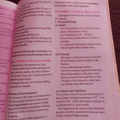 The image displays text from a book discussing the geography and development of a region in Nigeria. The text is presented in columns, with some sections highlighted in pink. The content covers topics such as settlement patterns, transportation, resources, economic activities, problems of development, and climate and vegetation. Specific locations mentioned include Nsukka, Enugu, Awka, and Onitsha, as well as the North-Central Highlands of Nigeria. The text also refers to the Hausaland plateau, Jos plateau, and various rivers and lakes. The image does not contain any visual elements of Jalingo, Nigeria or any people.