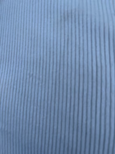 The image shows a blurred, close-up view of a light blue and gray striped fabric. There is no information in the image to indicate a location, people, subjects, objects, actions, or interactions related to Barakin Akawo, Nigeria.