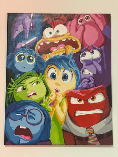 The image shows a vibrant, colorful painting of the characters from the Disney Pixar movie "Inside Out." The characters are arranged in a crowded composition, with some faces partially obscured. From left to right, and from bottom to top, the characters depicted are Sadness (blue, wearing glasses), Disgust (green, with a disgusted expression), Joy (yellow, with a bright smile and a curious expression), Fear (purple, with wide eyes and a worried expression), Anger (red, with a furious expression and wearing a shirt and tie), and in the background, there appears to be a glimpse of Bing Bong (pink elephant-like character) and another character with red hair and wide eyes. The painting is executed in a bold, graphic style with thick outlines and flat areas of color. The background is dark, which makes the characters stand out. The painting is mounted on a canvas and is displayed on a white wall.

There is no visual information in the image that provides any indication of its location in the city of Astana, Kazakhstan.