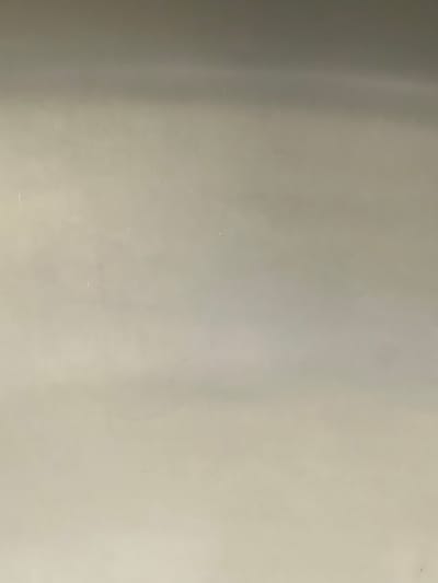 This is a close-up, high-angle shot of a textured, off-white wall. The lighting creates a gradient, with the top of the image being darker and transitioning to a lighter tone towards the bottom. There are subtle variations in shade and texture across the surface, suggesting it might be plaster or a similar material. There are no discernible objects, people, or actions in the image. The scene appears to be an interior wall. It is impossible to determine the specific location within Casablanca, Morocco, or any other contextual information based solely on this image of a wall.