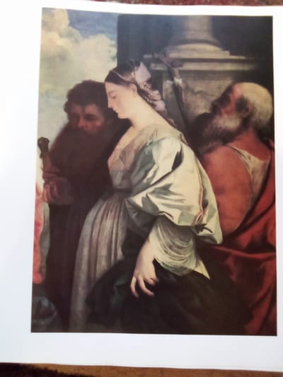 This is a photograph of a painting depicting a scene with three individuals. In the center is a young woman with fair skin and dark hair, styled with a ribbon. She is wearing a light-colored dress with voluminous sleeves and a lighter fabric draped over her shoulders. Her gaze is downcast, and her expression is serene. To her left, a man with dark hair and a beard is partially visible, his face turned towards the woman. To the right of the woman, an older man with a white beard and balding head is seen from the side, wearing a red garment. The background suggests an indoor setting with architectural elements like a column. The lighting in the painting is dramatic, with strong contrasts, typical of Baroque art. The overall mood is solemn and contemplative. No visible text is present in the image or on the painting. The context provided of Zhmerynka, Ukraine, does not appear to be directly represented within the painting itself.