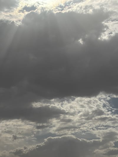 The image depicts a cloudy sky, with a large, dark cloud dominating the center and right side. Rays of light penetrate the clouds on the left. The overall impression is one of overcast weather conditions. The city of Sidi Bou Othmane, Morocco is not evident in this image.