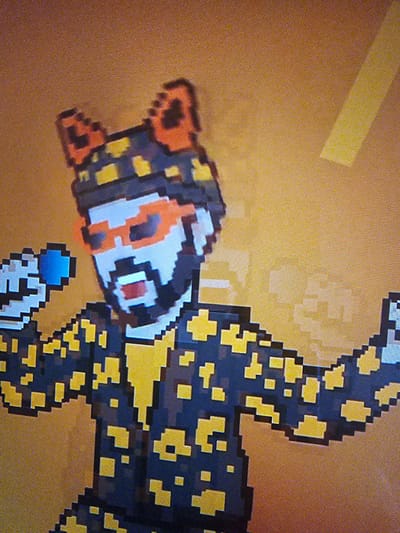 The image depicts a pixelated, digital rendering of a stylized tiger-like creature with a black body and yellow spots. The head is white with orange markings around the eyes and nose. The tail is curved upward. The background is a solid orange color with a yellowish horizontal bar in the top left corner. There is no indication of Holywell, United Kingdom in the image.