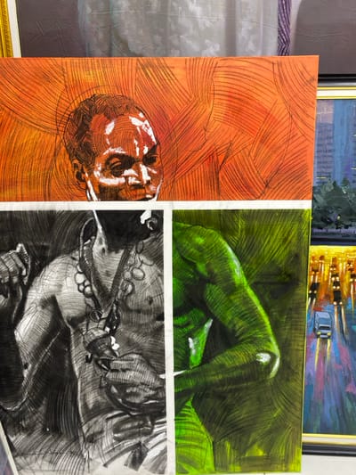 This image, captured in Ikate, Nigeria, displays a dense arrangement of multiple artworks, primarily paintings and drawings.
In the upper-center, a horizontal rectangular artwork features a head and shoulders portrait of a dark-skinned individual with white facial markings, set against an orange background with radiating black lines.
Immediately below this, two vertical rectangular artworks are positioned side-by-side, separated by a thin white vertical strip. The left artwork is a monochromatic charcoal or pencil drawing depicting the torso and raised right arm of a person, adorned with a beaded necklace and a hanging object. The right artwork is a vibrant green-hued depiction of a human torso or limb, rendered with visible strokes and dark outlines, accented by white highlights.
To the far right, partially visible, is a framed vertical painting portraying an impressionistic nighttime cityscape with illuminated buildings, a street, and vehicle lights, including a white car.
In the upper-left background, a portion of an ornate gold frame is visible, bordering what appears to be another artwork or draped material in muted grays and purples. The artworks are arranged vertically, suggesting they are either freestanding, leaning, or mounted for display within an interior space.