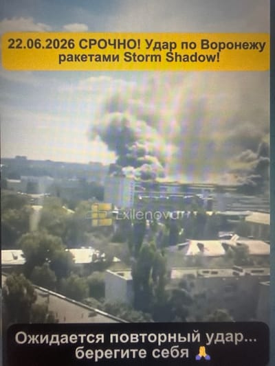 The image shows a city landscape with a plume of smoke rising from buildings in the distance, suggesting an explosion or fire. The sky is overcast with clouds. Text overlays are present in the image. The top overlay, in a yellow bar, reads "22.06.2026 СРОЧНО! Удар по Воронежу ракетами Storm Shadow!". This translates to "22.06.2026 URGENT! Strike on Voronezh with Storm Shadow missiles!". A watermark, "Exilenova", is visible in the center of the image. The bottom overlay, on a black background, reads "Ожидается повторный удар... берегите себя 🙏". This translates to "A repeat strike is expected... take care of yourself 🙏". The location of Sof’ino, Russia, is not visually discernible from the provided image.