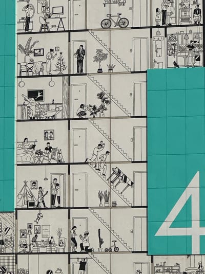 This detailed illustration depicts a vertical cross-section of a multi-story residential building located in Бараўлянскі сельскі Савет, Belarus. The scene is rendered in black and white line art, portraying diverse domestic activities across multiple apartments and common areas. The right side of the image is partially obscured by a teal panel displaying a large white numeral "4".
From top to bottom, the depicted scenes include:
* **Topmost Level:** An apartment contains a man flexing his torso, and another muscular man posing next to a desk with a computer. A bicycle is parked in the adjacent common hallway. Another apartment shows a family of three standing, while two men are present in a kitchen setting.
* **Second Level:** A woman in a robe decorates a small Christmas tree. In the hallway, a man in a suit stands in a doorway. An apartment kitchen features a woman standing at a counter with a black cat beside her, and a dog sitting on the floor.
* **Third Level:** A ballerina stretches on a platform in an apartment. A person kneels to water potted plants in the common area. An apartment shows a woman using a laptop in bed, while a man reads in a chair next to her, accompanied by a dog.
* **Fourth Level:** A man and woman run down a flight of stairs, appearing in haste. In the adjacent stairwell, two men precariously carry a grand piano down the stairs.
* **Fifth Level:** An apartment features a boy playing an electric guitar near a teepee, and a man holding a child in a doorway. In another apartment, a man kneels, proposing to a woman.
* **Sixth Level:** A person performs a pull-up on a bar in an apartment. In the common area, a person sits on a bicycle. An apartment is densely populated with numerous cats, with one person also present.
* **Bottommost Level:** Partially visible, further domestic scenes and common areas continue.
Stairs are a prominent feature, connecting all visible floors in the common areas. Elevators are also present on multiple levels. Various potted plants are situated throughout the building, both inside apartments and in hallways.