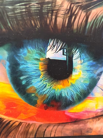This is a close-up, artistic representation of a human eye, likely a painting or digital artwork. The iris is depicted in vibrant hues of blue, green, and yellow, with intricate details of its radial patterns and the pupil as a dark void. The eye appears to be looking towards the left of the frame, with reflections of light and possibly the surrounding environment visible on its surface, including what seems to be a rectangular object with white and blue tones.
To the left of the eye, abstract lines in shades of brown and grey suggest eyelashes or the outer edge of the eye socket, rendered in a textured, almost metallic style. To the right of the eye, large swathes of bright color, primarily oranges and yellows, along with some red and pink, create a vibrant, abstract background that could represent light, abstract shapes, or possibly other parts of the face, like the cheek or forehead. The overall impression is one of intense focus and a dreamlike, surreal quality due to the exaggerated colors and abstract elements. The artwork has a grainy texture, possibly due to the medium or a photographic effect, and small white specks are scattered across the surface, resembling dust or imperfections. There is no discernible text in the image. The setting and time of day are not indicated, but the intense lighting and vibrant colors suggest an artificial or highly stylized environment. The emotion conveyed is one of deep contemplation or perhaps awe.