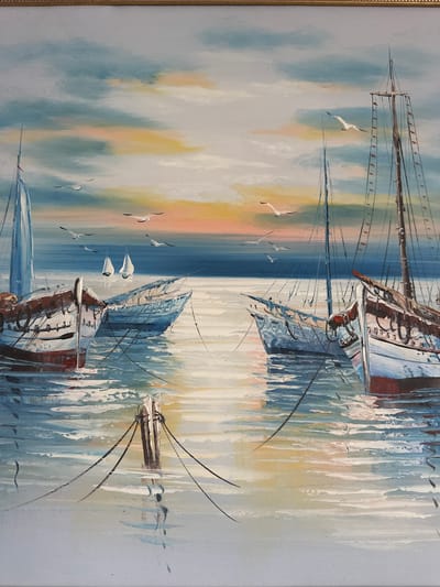 This is a painting of sailboats at anchor in calm water. The sky is depicted with soft clouds in shades of blue, white, and hints of orange and pink, suggesting either sunrise or sunset. Several seagulls are painted in flight across the sky. In the foreground, several sailboats are moored. One large sailboat with a tall mast and rigging dominates the right side of the composition. Another sailboat with a blue hull is positioned to the left of it. In the distance, two smaller sailboats with white sails are visible. The water reflects the colors of the sky and the boats. The overall scene is serene and picturesque, with a focus on the interplay of light and water. This painting does not depict any specific location in Vilnius, Lithuania.