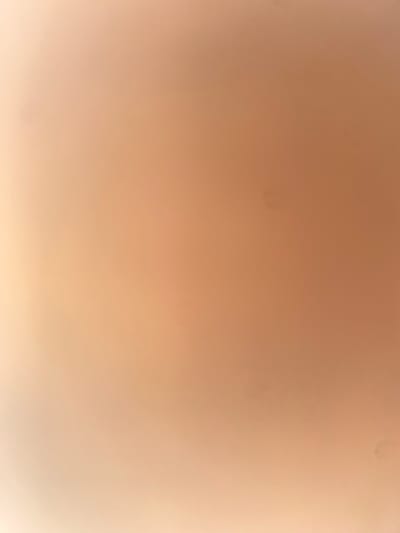 The image is an abstract, out-of-focus photograph with a warm, peachy-tan color gradient. The lighting is soft, creating a gentle transition from a brighter, lighter area on the left to a darker, more saturated area on the right. There are a few small, dark specks visible, which could be dust or imperfections in the image. The overall impression is one of softness and warmth, with no discernible objects or subjects in focus. The image does not contain any visual information that can be linked to the city of Ablanitsa, Bulgaria, or any specific location.