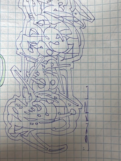 The image is a close-up, overhead shot of a blue ink drawing on graph paper. The drawing depicts an abstract, mechanical-looking object with intricate, interlocking shapes and gears. It appears to be a technical sketch or a conceptual design. The drawing is incomplete, with some lines faded and parts of the image cut off. There is no indication of the city of Barnaul, Russia, or any other specific location.
