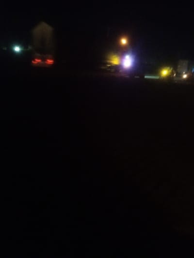 The image is a blurry, dark photograph taken at night. It appears to be an outdoor scene with several lights visible. In the upper left, there is a bright white light, and to its right, a building with red lights, possibly taillights of a vehicle. Further to the right, there are other lights, including a yellow light, a purple light, and a bright white light, suggesting streetlights or other artificial illumination. The overall impression is of a street or an open area at night, possibly with vehicles and buildings in the distance. The image lacks clear details due to the low light conditions and blurriness. No people or specific landmarks that would indicate Nassarawa, Nigeria are discernible.