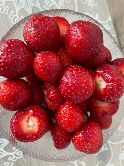 This media file features a close-up, overhead shot of a clear glass bowl filled with fresh, ripe strawberries. The strawberries are a vibrant red, with visible seeds and some showing hints of white flesh where they have been bitten or are partially cut. The bowl itself has a textured, slightly ribbed pattern on its exterior. The strawberries are piled high, creating a visually abundant display.
The setting appears to be indoors, with a light-colored, textured surface visible beneath the bowl. This surface has a subtle pattern, possibly a tablecloth or placemat. The lighting suggests daytime, with diffused light illuminating the fruit without harsh shadows. There are no people or animals visible in the image.
The activity depicted is simply the presentation of the strawberries, suggesting they are ready to be eaten or have been recently prepared. The overall impression is one of freshness and natural bounty. There is no visible text within the image. The location context of Brovary, Ukraine, provides an external geographical reference but is not visually depicted in the media itself.