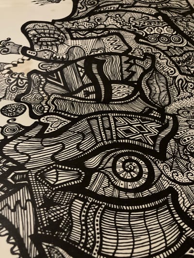 This is a close-up, black and white, high-angle photograph of a highly detailed, abstract pen and ink drawing. The drawing is densely packed with intricate patterns and motifs, including spirals, zigzags, lines, dots, and geometric shapes. There are no discernible figures of people or recognizable objects; the subject is the artwork itself. The drawing appears to be on a white or cream-colored surface, possibly paper or a wall. There is no visible text within the image. The style is reminiscent of Zentangle art or other forms of intricate doodling, with a strong emphasis on texture and visual complexity. The lighting appears to be artificial, casting no distinct shadows that would indicate a specific time of day or natural weather conditions. The overall impression is one of meticulous craftsmanship and an exploration of abstract form and pattern. The context of Sabadell, Spain, does not provide any specific visual cues within the image itself, but suggests the origin of the artwork.