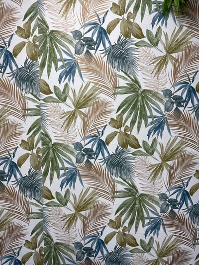 The image is a photograph of a patterned textile, likely wallpaper or fabric, featuring a tropical leaf motif. The design incorporates various types of leaves in shades of green, brown, and blue, with some leaves having a subtle metallic sheen. The leaves are rendered in a watercolor style, creating a soft and artistic effect. The background is a plain white. There are no people or specific landmarks visible in the image. The image does not provide any information to suggest a location in Torrejón de Ardoz, Spain.