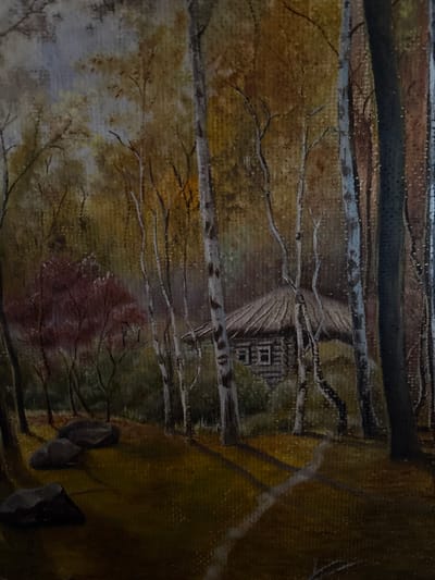 This is a painting of a forest scene, likely in autumn given the muted, warm colors of the foliage. In the center of the painting, partially obscured by trees, is a small, rustic wooden cabin with a thatched roof and two visible windows. The cabin appears to be made of logs. Surrounding the cabin is a dense forest with numerous trees of varying sizes and bark textures, some appearing to be birch with their distinctive white and dark markings, while others have darker, rougher bark. Sunlight filters through the leaves, creating dappled patterns on the forest floor. In the foreground, there are several large, dark stones, and a winding path is faintly visible. The overall atmosphere is serene and somewhat secluded. The image does not depict the city of Tutaev, Russia, nor does it show any people or specific actions.