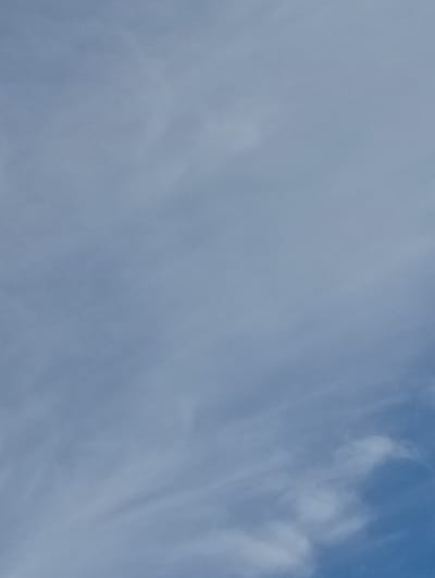 The image shows a cloudy sky above Pavlovsky Posad, Russia. The clouds are predominantly white and wispy, with some denser patches visible. The sky is a light blue, indicating it is daytime. No people, subjects, objects, or actions are identifiable in this image. The scene is an outdoor environment focused on the sky.
