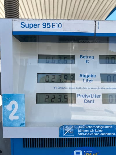 The image shows a close-up of a fuel pump display at a gas station, likely in Furtwangen im Schwarzwald, Germany, given the German text on the display. The display shows information about "Super 95 E10" gasoline. It indicates a "Betrag" (amount) of 06.26 € and "Abgabe Liter" (dispensed liters) of 027.98. The "Preis/Liter Cent" (price per liter in cents) is 223.9. There is also a blue square with the number "2" on the left side of the display. A sticker at the bottom states, "Aus Sicherheitsgründen können wir keine 500-€-Scheine annehmen," meaning "For security reasons, we cannot accept 500 € notes." Below this, it says "Je Liter" (per liter) and a price of "94 ct*". The background shows the corrugated roof of the gas station. There are no people visible in the image.