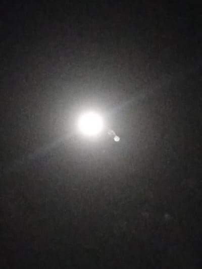 The image depicts a night scene in Nata-Ala, Nigeria. A bright, full moon dominates the center of the frame, radiating light across the dark sky. No people, objects, or specific environmental features are discernible other than the night sky.