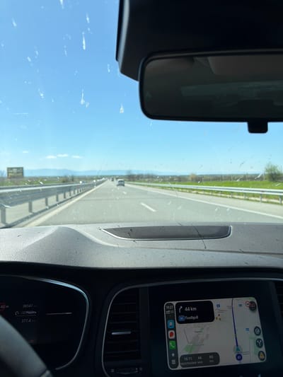 The image appears to be taken from the interior of a car traveling on a highway. The navigation system indicates the destination is "Пловдив," approximately 44 km away. The timestamp on the navigation system shows 14:27, with an estimated time of arrival at 15:11. The odometer reads 38547 km, and the fuel range is 377.4 km. The location may be near Rupkite, Bulgaria, based on the "Чирпан" displayed on the navigation system, which is a nearby city. The weather seems clear with a blue sky visible through the windshield.