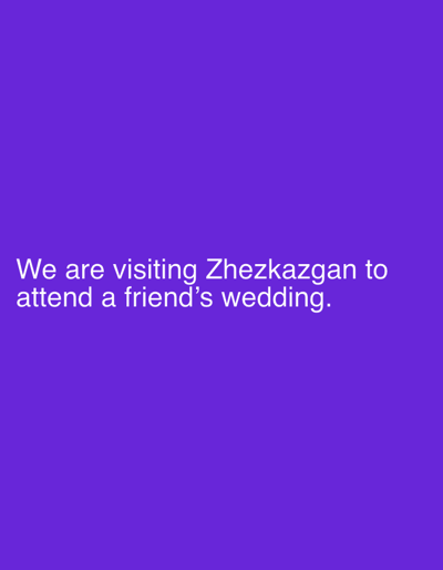 The image is a photograph of text on a solid purple background. The text reads: "We are visiting Zhezqazğan to attend a friend's wedding." The text is white and appears to be in a sans-serif font. The background is a uniform shade of purple, with no discernible objects or people in the image. The city of Zhezqazğan, Kazakhstan is mentioned in the text.