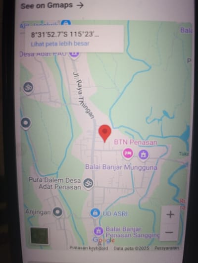 The image shows a screen capture of Google Maps. The coordinates of the location shown in the map are 8°31'52.7"S 115°23'... The location is Kecamatan Arjasa, Indonesia. The map shows the following features: a road labeled "Jl. Raya Thingan," a place called "BTN Penasan," "Balai Banjar Mungguna," "Pura Dalam Desa Adat Penasan," "Anjingan," "UD ASRI," "Balai Banjar Penasan Sangging," and "Desa Adat Penasan." There is a red marker on the map indicating the location. The screen also shows a blue button that says "See on Gmaps" and a button that says "Lihat peta lebih besar". The bottom of the screen shows text in Indonesian that says "Pintasan keyboard" (keyboard shortcut), "Data peta ©2025" (Map data ©2025), and "Persyaratan" (Requirements). There is a green icon, a blue circle, and a pink icon at various locations on the map. The map is set in a dark gray and white color scheme.