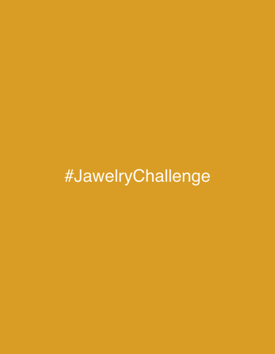 The image displays a solid, uniform mustard-yellow background. Horizontally centered in the lower middle section of the frame is white text that reads "#JewelryChallenge". No individuals, specific subjects beyond the text, objects, actions, or interactions are depicted. The visual content provides no discernible information to establish a geographical location within the city of Gbongan, Nigeria, or any other specific area.