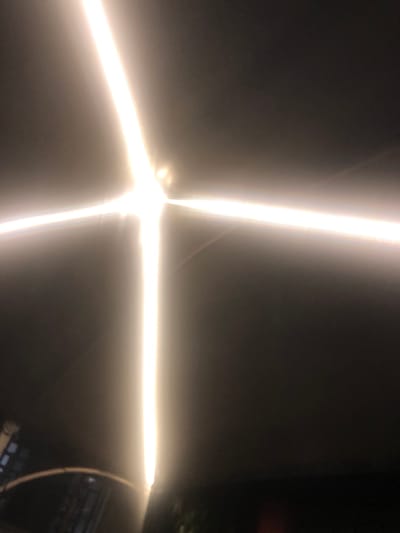The image shows an out-of-focus, abstract pattern of bright, intersecting lines against a dark background. The lines appear to be linear light sources. In the lower right corner, there is a hint of a darker object that is not clearly distinguishable. There is no information available in the image to determine the location in Hanwa, Nigeria. There are no people visible in the image.