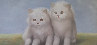 This is a painting of two fluffy white cats sitting in a grassy field with a soft blue sky in the background. The cat on the left is slightly smaller and positioned closer to the viewer, while the cat on the right is larger and sits slightly behind and to the right of the first cat. Both cats have large, expressive amber eyes and small pink noses. Their fur is rendered with soft brushstrokes, giving them a plush appearance. The foreground depicts a field of green and yellow grass, with some taller blades of grass visible. The background is a gradient of light blue, suggesting a clear sky. There is no discernible location in Lahti, Finland, or any other specific geographical area.