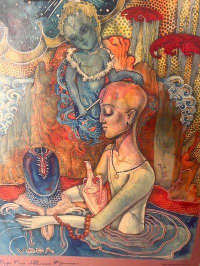 This is a surreal, stylized watercolor painting featuring two figures. The dominant figure, on the right, is an adult with pale skin, lying on their side with their eyes closed and head resting on an orange and blue patterned surface. They have a thin, dark necklace with a pendant. Their body is depicted in muted green and pink tones, with flowing blue drapery behind them. Red beaded bracelets adorn their wrist. To the left is a smaller, childlike figure with blonde hair, also lying down. This figure has blue-toned skin and is wearing a white ruffled garment. They are looking upwards with a somewhat vacant expression and are wearing glasses. A thin white stick or rod is held in their hand.
The background is a chaotic and abstract mix of colors and patterns. There are swirling blue and white wave-like forms, dotted textures in yellow and green, and vibrant red areas. The overall mood is dreamlike and perhaps unsettling, with a sense of distorted reality. There are no clear indicators of time of day, weather, or a specific geographical location, though the artist's style might evoke an Eastern or psychedelic aesthetic.
Visible text is present along the right edge of the image, oriented vertically. It reads "VEDARAM.UCOZ.RU" and "Веда Рам "Явление Крнмашь"" in Cyrillic. The latter phrase translates roughly to "Veda Ram 'Appearance of Krinmash'". This suggests the artist's name and the title of the artwork or series.