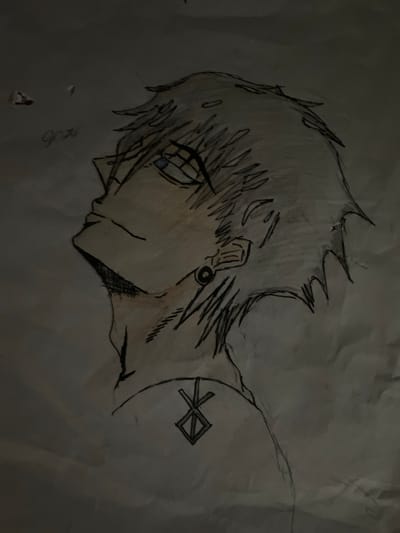 A pencil sketch of an anime-style character's head and shoulders is depicted on a crumpled piece of paper. The character is looking upwards and to the left, with spiky hair and a partially visible eye with blue iris. The character has a tattoo on their left shoulder blade, which appears to be a rune. There are faint handwritten words "good" in cursive in the upper left corner, along with a few smudges that appear to be red ink. The sketch is illuminated by a single light source, casting shadows and highlighting the texture of the paper. The specific location within Elizabeth City, United States, cannot be determined from the image alone.