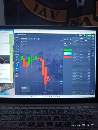 This image captures a laptop screen displaying a trading platform, likely for financial markets, with a real-time chart showing fluctuating prices. The chart features candlestick patterns in red and green, indicating periods of losses and gains, respectively. To the left of the chart, a sidebar menu provides various trading-related options such as "Trading," "Finance," "Profile," and "Market." On the left side of the screen, a window from "Telegram Desktop" is visible, showing chat messages with some text in Ukrainian, mentioning trade bots and financial advice.
The trading platform itself prominently displays "EUR/JPY OTC" and a current balance of "496.49" UAH. A list of recent "Trades" is shown below the chart, detailing the type of asset (e.g., "Tesla OTC," "Apple OTC"), profit percentages, amounts, and times. The time displayed on the trading platform's chart ranges from 12:27:15 to 12:30.
The bottom part of the image shows a keyboard, indicating this is a personal computer setup. The date and time "26.06.2026 12:29" are overlaid on the keyboard area, suggesting a future time relative to the actual capture, or a timestamp from the device's clock. The overall scene is an indoor setting, likely a desk, where someone is engaged in online trading. The background behind the laptop shows a blurred image with large letters, possibly a decorative element or part of a wall. The environment appears to be a home or office setting, and the activity is focused on digital finance and trading. There are no people visible in the frame.