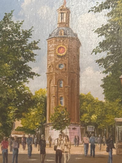 The painting depicts a public square in the city of Steenwijk, Netherlands, dominated by a tall, brick tower. The tower has a clock with a red face and Roman numerals, and is topped by a spire with a small structure at its peak. The tower is flanked by lush green trees. In the foreground, a group of people are walking across a paved area. The people are depicted in a casual manner, some walking individually and others in pairs. The atmosphere appears to be daytime, with a bright sky and dappled sunlight filtering through the trees. The painting style is realistic, with attention to detail in the architecture and the rendering of the people and foliage. The overall impression is a lively, urban scene set against a historical backdrop.