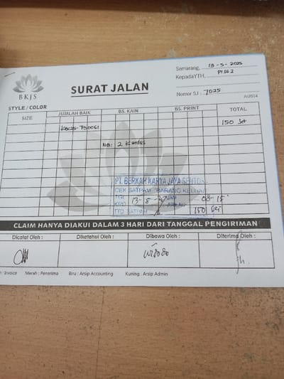 The image shows a document titled "Surat Jalan", which appears to be a delivery note. It is dated "13-5-2023" and numbered "7025", with a company logo showing a flower. The total amount is 150 "Jt", with a "Pcs" unit, and it is labelled "A2014". The document is filled out with hand-written information, including "Kecs-B0061", "NB: 2 Kardus", and a signature in the "Dibawa Oleh" section. The document also includes an internal company stamp with the details "PT Berkah Karya Jaya Sentosa" and "Cek Satpam Barang Keluar". The document states that "Claim Hanya Diakui Dalam 3 Hari Dari Tanggal Pengiriman" and indicates the recipients for each part of the document: red for "Penerima", blue for "Arsip Accounting", and yellow for "Arsip Admin". It is from Semarang, Indonesia, with coordinates (-7.01, 110.364). The image is of a document on a desk with a white background.