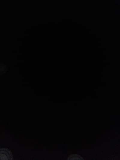 This is a dark, underexposed image of an outdoor scene, likely taken at night or in very low light conditions. The majority of the frame is black, making it difficult to discern specific details about the environment or any activity taking place.

In the lower right quadrant of the image, there are faint, circular shapes that appear to be objects, possibly illuminated from above or reflecting light. These shapes are indistinct and lack clear definition. There is also a hint of a lighter, textured surface near these circular objects.

Due to the extreme underexposure and lack of clear visual information, it is impossible to identify any specific subjects, activities, or notable details such as time of day, weather, location cues, or emotions. No text is visible in the image. The provided location context of Slobozia-Dușca, Moldova, cannot be corroborated by any visual evidence within the photograph itself.