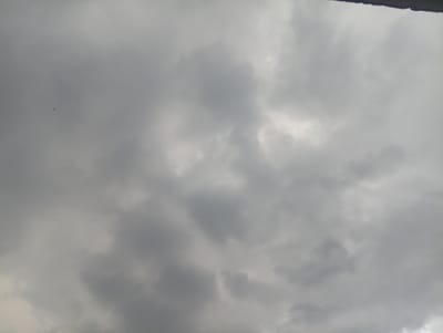 The image shows a cloudy sky, possibly taken on an overcast day. There are no distinct features indicating the time of day or specific location, other than the provided context of Langenthal, Switzerland. The clouds are varied in texture and shade, with some appearing darker and more dense than others, suggesting a potentially moody or approaching weather system.

In the upper left quadrant of the image, a small, dark silhouette of a bird is visible in flight. Further down and towards the center, another even smaller, darker silhouette of what appears to be a bird is also present. These are the only discernible subjects in the frame. The overall impression is one of a natural outdoor scene, with the focus being on the atmospheric conditions of the sky. There is no visible text within the image.