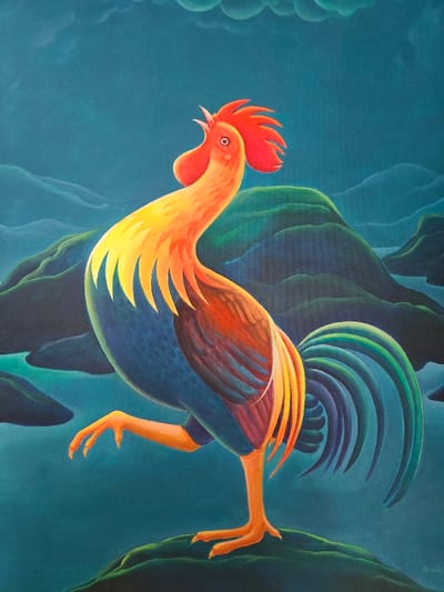 This image is a vertical painting featuring a stylized rooster against an abstract landscape. The central subject is a large rooster depicted in profile, facing left, with its head tilted upwards and beak open, suggestive of crowing. Its head, neck, and upper back are rendered in bright yellow and orange hues, transitioning to darker orange and red on its wings. The rooster's body is deep blue, and its prominent comb and wattles are vibrant red. Its tail feathers display a curvilinear design in shades of blue, green, and yellow. The rooster stands on its right leg, with its left leg raised and bent. It is positioned on a dark green, undulating foreground landform. The background features a series of dark blue-green hills or islands interspersed with bodies of teal-blue water. The sky is a dark teal with subtle, lighter cloud formations in the upper left quadrant. The scene is an artistic creation and does not depict a specific, identifiable real-world location within the city of Kochi, India.