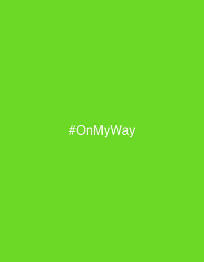 The image consists of a uniform, solid lime green background occupying the entire frame. Centered within this background, rendered in white sans-serif lettering, is the hashtag text "#OnMyWay". No people, additional subjects, objects, actions, interactions, or discernible environmental features are present. The image does not visually depict any specific location within Lipomo, Italy, or any other physical environment.