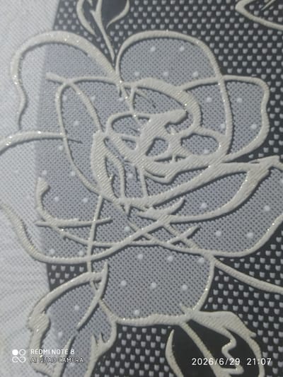 The image is a close-up of a decorative pattern featuring a stylized white rose with a glittery outline against a textured background. The background alternates between a light gray with small white dots and a dark gray or black with a repeating small, abstract pattern. The rose design is intricate, with layered petals and swirling lines suggesting stems or leaves. The overall aesthetic appears to be part of a textile or wallpaper design. In the lower left corner, a watermark reads "REDMI NOTE 8 AI QUAD CAMERA". In the lower right corner, a timestamp is visible: "2026/6/29 21:07". The image is not a depiction of a scene in Baýramaly, Turkmenistan, as it shows an abstract pattern and not any recognizable city landmarks or elements.