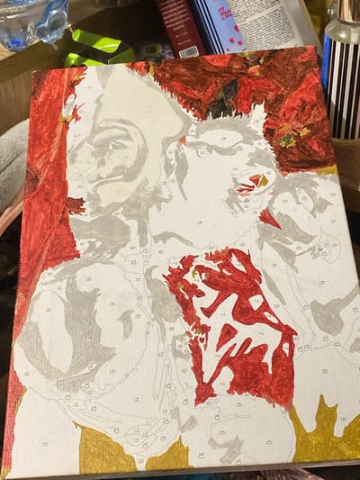 The image shows a partially painted canvas. The painting appears to be a "paint-by-numbers" kit, with visible numbers on the canvas indicating where to apply specific colors. The painting depicts a portrait, possibly of a woman, with shades of red, grey, and gold paint applied in certain sections. The background is mostly white, with some areas of darker red and brown. The canvas is placed on a surface that appears to be a table or desk, with various items in the background, including a plastic bottle of water, a green object, and some books or packaging with text. The image is a close-up shot, focusing on the painted canvas. There is no information to suggest the location is the city of Nova Praha, Ukraine.
