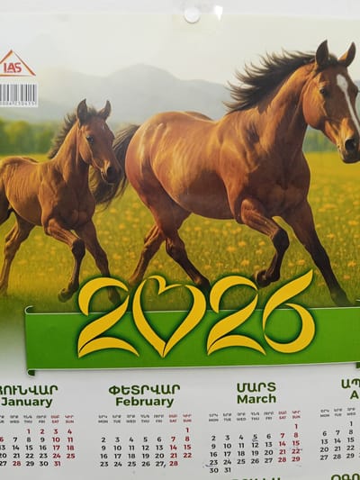 The image is a calendar page featuring two horses in a grassy field with mountains in the background. The calendar prominently displays "2020" in large yellow numbers at the bottom. The months of "January," "February," and "March" are visible, each with corresponding days of the week and dates. The text is in Armenian and English. The presence of Armenian text and the LAS logo, a printing company based in Yerevan, Armenia, suggests this calendar is a product from Armenia. While the image itself doesn't contain elements directly linking it to Ashtarak, Armenia, it is possible this calendar was printed or used in that region, as it is a common practice for businesses and individuals in Armenia to display such calendars.