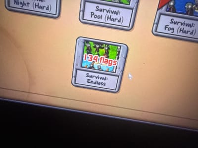 The image shows a computer screen displaying the Plants vs. Zombies game menu. There are multiple game mode selections displayed. In particular, "Survival: Endless" is highlighted with the number "134 flags," referring to the amount of flags survived in the game mode. The other selectable game modes are "Survival: Night (Hard)," "Survival: Pool (Hard)," and "Survival: Fog (Hard)." The background of the menu appears to be a beige/tan color. A computer mouse cursor is also visible on the screen. The lower part of the image shows the edge of the computer monitor. The picture does not show Acapulco, Mexico.