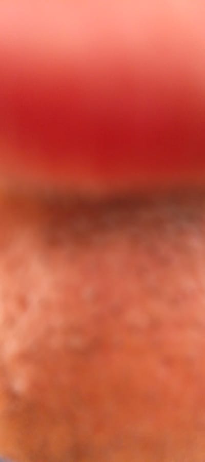 This is an abstract, out-of-focus image dominated by warm tones of red and orange. The top portion of the image features a gradient from a lighter pinkish-red to a deeper, more saturated red. Below this, the image transitions to a mottled texture of various shades of orange and brown, appearing soft and diffused. There are no discernible objects, people, or actions within the frame. The image does not provide any information about its location, including in the city of Mehrabad, Uzbekistan.