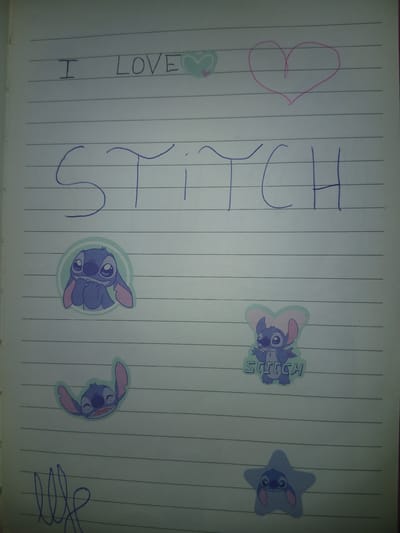 A lined notebook page displays handwritten text and stickers. At the top left, "I LOVE" is written in blue marker, with a small blue heart next to "LOVE". To the right of this, a pink outline of a heart is drawn. Below this, the word "STITCH" is written in large blue letters. Several stickers of the character Stitch are present: one in the middle left shows Stitch with his hands near his mouth, a second sticker in the middle right shows Stitch with his arms outstretched and the word "STITCH" below him, and a third sticker at the bottom right shows Stitch within a blue star. A scribbled blue mark is visible in the bottom left corner. The image does not depict or contain any information related to Navaluenga, Spain.